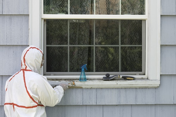 worker in hazmat suit removing lead paint